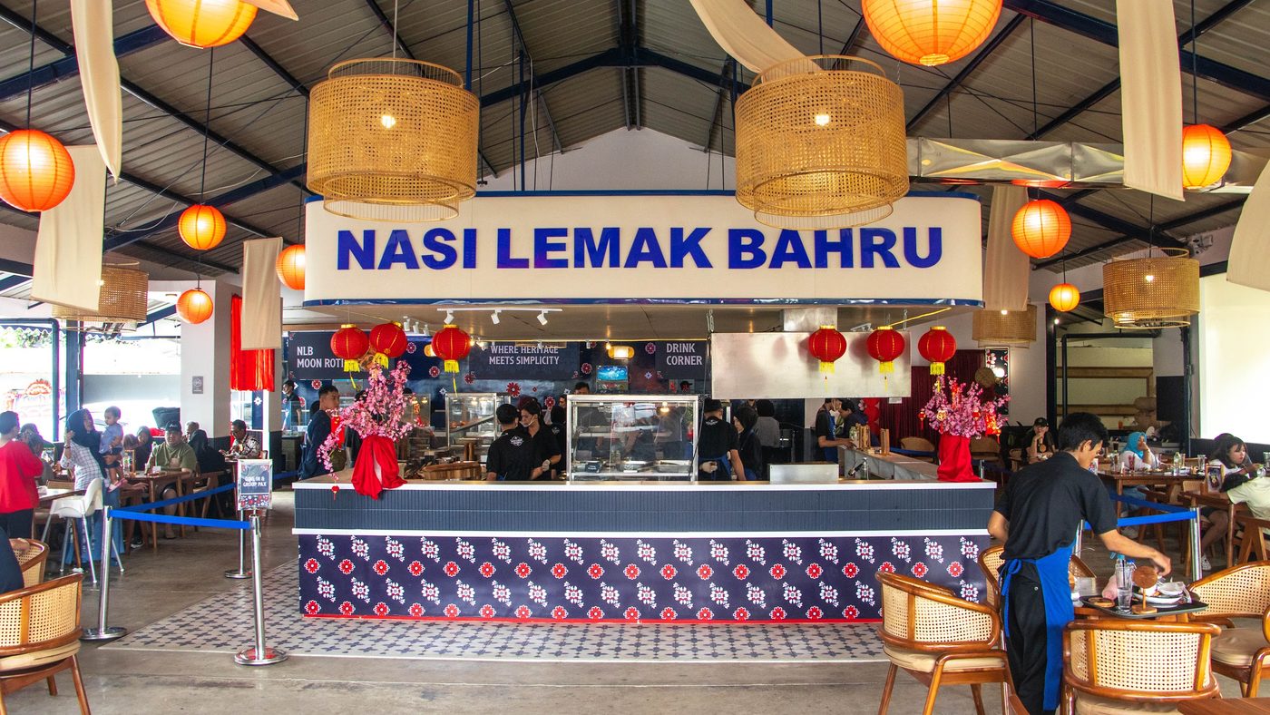 The Nasi Lemak Bahru outlet in Bogor — counter, rattan lamps and guests