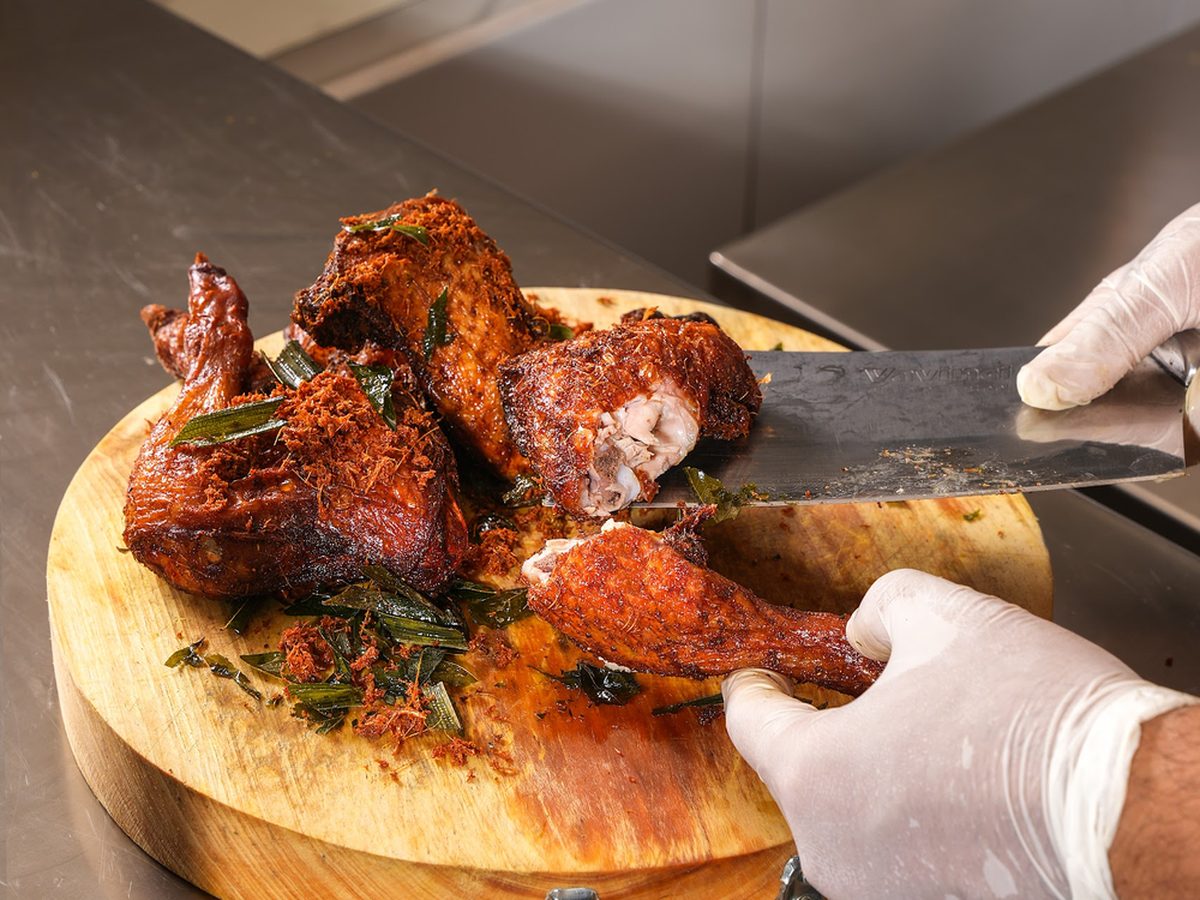 Ayam rempah being carved on a wooden board