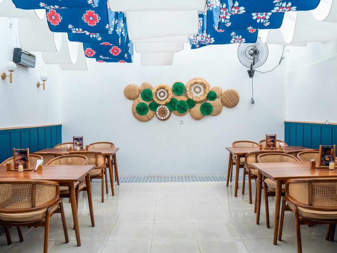 Dining room dressed with blue batik banners and woven ketupat